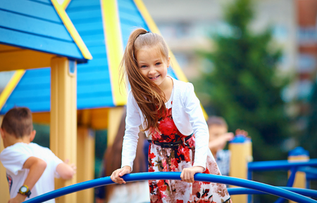 happy young girl playing on outdoor playgroundの写真素材