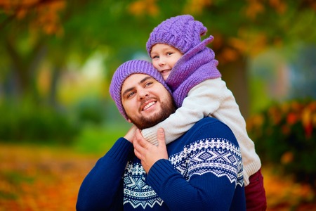 portrait of happy father and son embracing in autumn parkの写真素材
