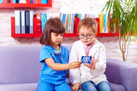 cute kids playing doctors in officeの写真素材