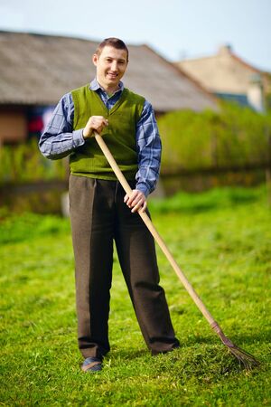 happy young adult man with disability working in spring gardenの写真素材