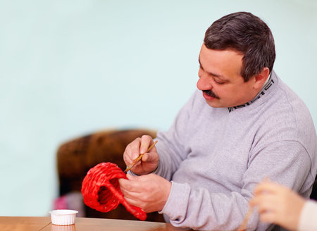 young adult man engaged in craft work in rehabilitation center