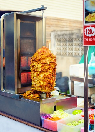 roaster with meat and vegetables at street marketの写真素材