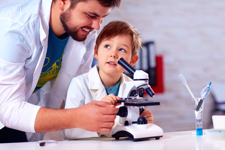 teacher helps kid to conduct experiment with microscope