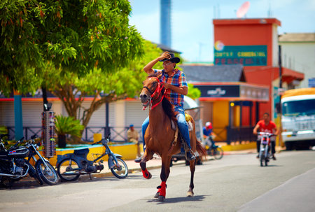 DOMINICAN REPUBLIC - AUGUST 30, 2015:  Young cowboy riding a horse on the city roadのeditorial素材