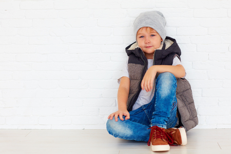 portrait of fashionable kid near the wallの写真素材