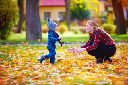 cute little boy having fun with mother in autumn parkの写真素材