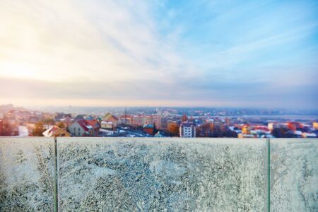 freezing outside, winter cityscape through the glass banisters covered with frostの写真素材