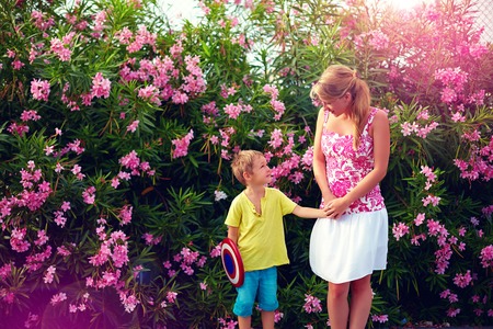 young woman and kid talking in front of blooming gardenの写真素材