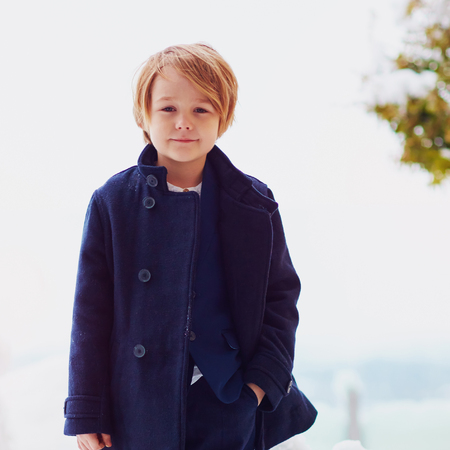portrait of cute fashionable boy in winter coat, outdoorsの写真素材