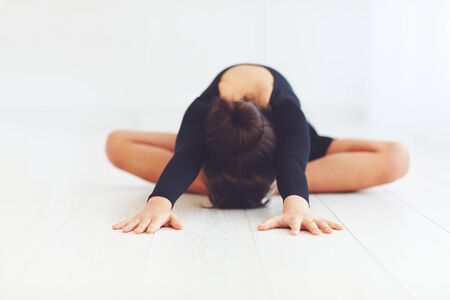 cute girl makes stretching exercises on dance class in ballroom schoolの写真素材