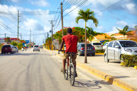BAVARO, DOMINICAN REPUBLIC - 09.01.2015: Undefined man riding on bicycle along the Bavaro city roadのeditorial素材