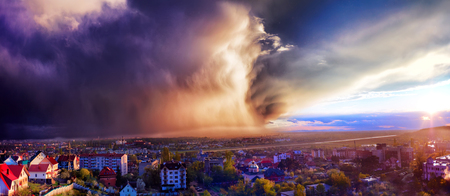 heavy rain approaching on the city at sunset lightの写真素材