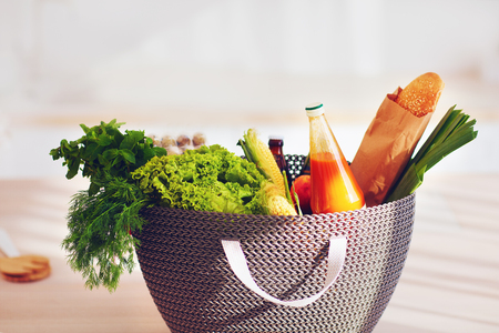 shopping bag full of fresh food on kitchen deskの写真素材