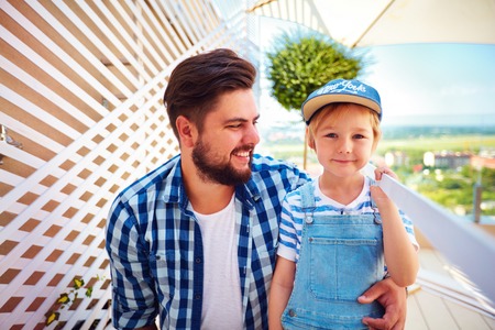 portrait of happy father and son, family repairing rooftop patio zone of the houseの写真素材