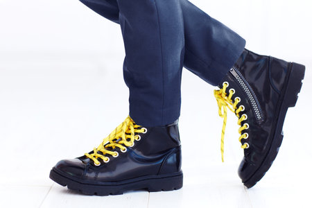 stylish look of patent leather ankle boots with yellow shoelaces and socks at young boyの写真素材