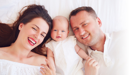 portrait of happy young mother and father with newborn baby girlの写真素材