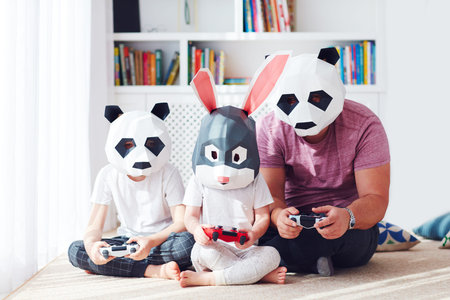 concept image of family in polygonal animal masks playing games on a play station console
