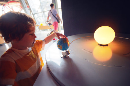 WARSAW, POLAND - June 20, 2019: Kid exploring the season and time of the day changing according to the Earth slope and its position relative to the Sun. The Copernicus Science Centre in Warsaw, Polandのeditorial素材