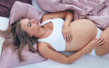 young pregnant woman relaxing in bed in the morning