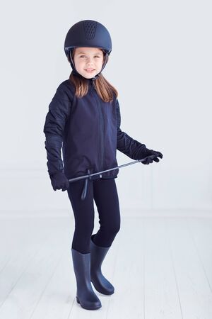 portrait of young kid girl in horseback rider outfitの写真素材
