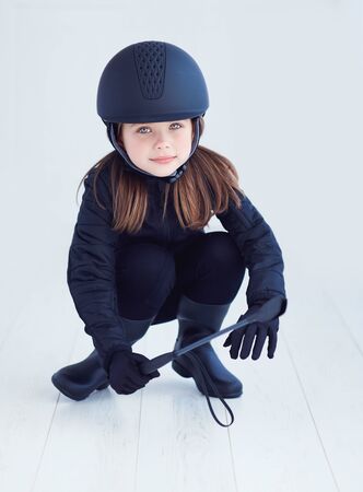 portrait of young kid girl in horseback rider outfitの写真素材