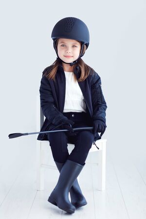 portrait of young kid girl in horseback rider outfitの写真素材