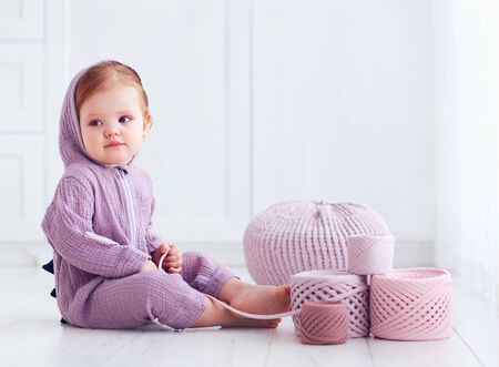 cute toddler baby girl with t-shirt yarn balls. upcycle. soft cottong fabric spoolの写真素材