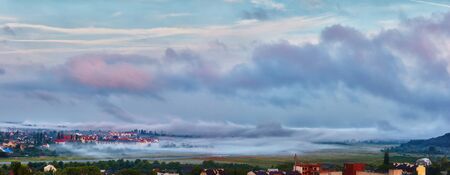 morning mist is like huge waves, that cover a sleeping city in a valley. Uzhhorod, Ukraineの写真素材