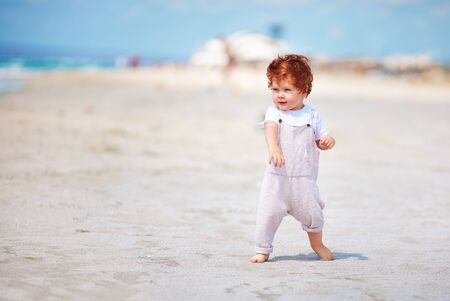 cute toddler baby boy walking on the sandy beach. summer vacationの写真素材