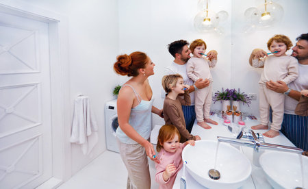 happy family brushing teeth together in the bathroom in the morning
