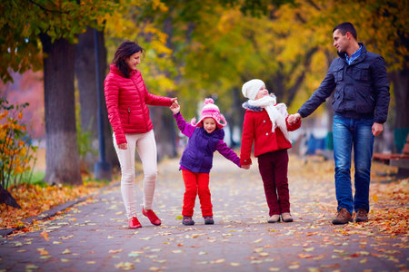 happy family walking together in autumn park