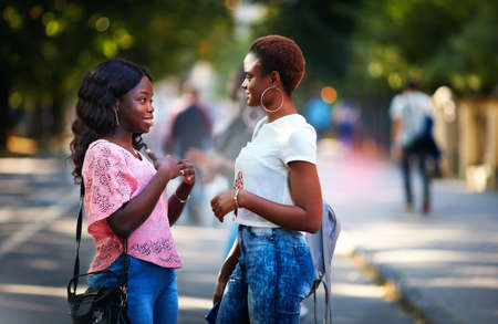 beautiful african american women talking on the crowded streetの写真素材