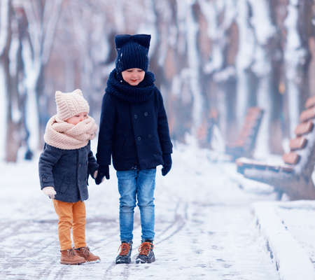 cute kids, brothers walking together in winter parkの写真素材