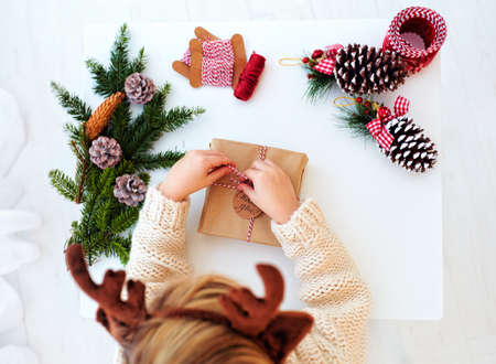 happy kid creates christmas decorations, wraps the presentsの写真素材