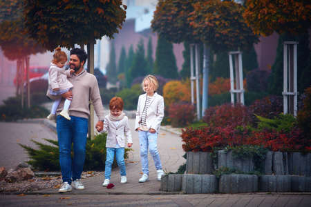 happy father with three children walking down the streetの写真素材