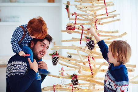 happy family, father with kids having fun, decorating eco friendly, reusable christmas tree on holidaysの写真素材