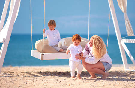 happy family, mother with kids playing on the beach during summer vacationの写真素材
