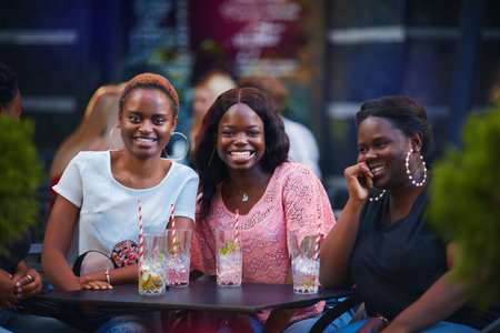 happy african american women, students having fun in summer cafeの写真素材