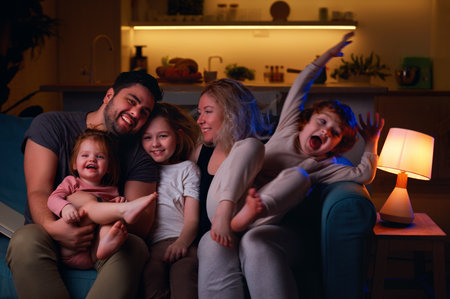 cheerful family having fun together at cozy home in the eveningの写真素材