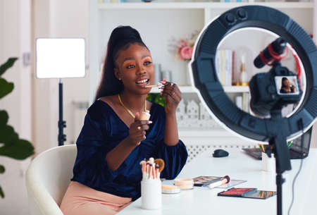 young african american woman streaming a beauty vlog from home, online content creatorの写真素材