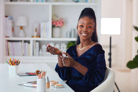 beautiful young african american woman applying a perfume fragrance at home, beauty bloggerの写真素材