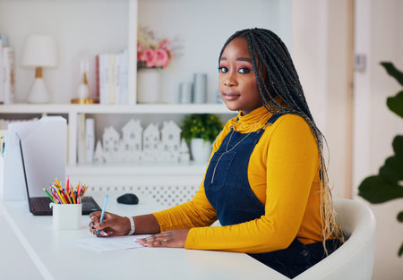 young african american woman writing notes or filling documents while sitting at the desk at home...