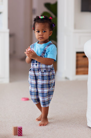 cute african american baby girl playing toys at homeの写真素材