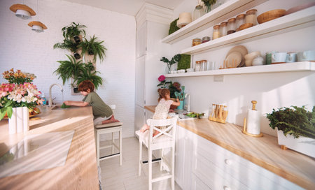 kids are busy with house chores on modern kitchen with wooden countertop and wall shelves