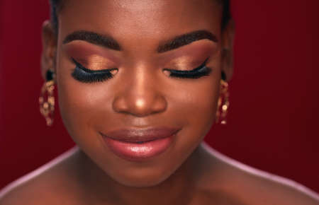 portrait of beautiful smiling african american woman on red backgroundの写真素材