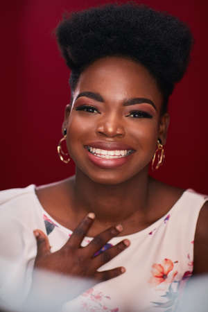 portrait of beautiful smiling african american woman on red backgroundの写真素材