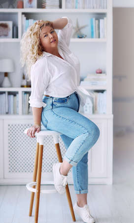 attractive plus size woman wearing high waist jeans and knotted shirtの写真素材