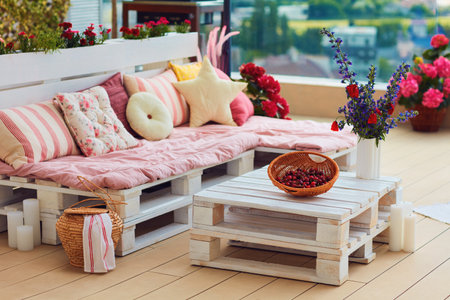 cute, cozy pallet furniture with colorful pillows at summer patio, lounge outdoor spaceの写真素材