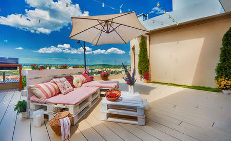 cute, cozy pallet furniture with colorful pillows at summer rooftop patio, lounge outdoor spaceの写真素材