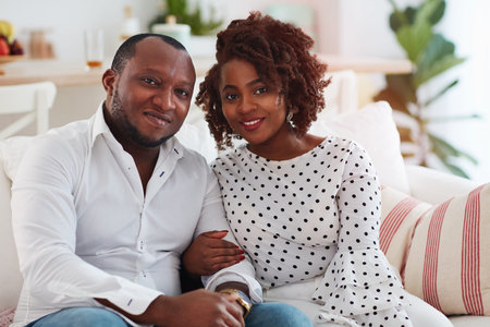 portrait of happy young adult couple sitting together at homeの写真素材